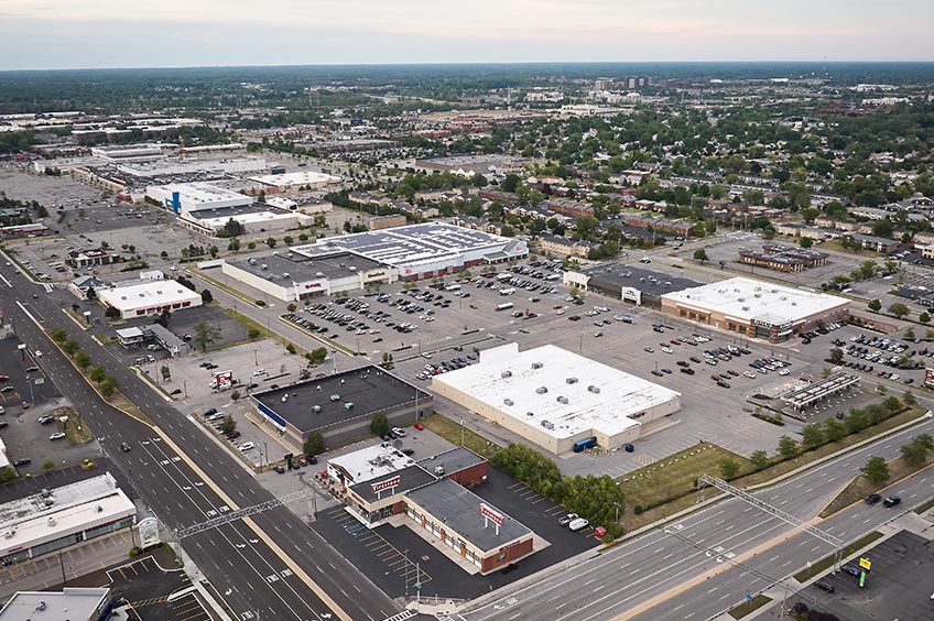 Overhead shot of Amherst Commons shopping center and its adjacent parking lot, captured from a high vantage point.