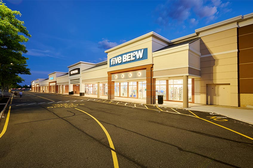 Sidewalk and shop storefront at Brick Commons shopping center.