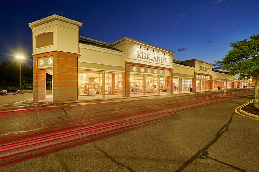 Sidewalk and shop storefront at Brick Commons shopping center.