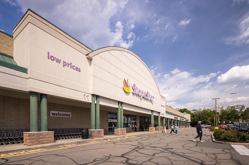 Sidewalk and shop storefront at Carlstadt Commons shopping center.