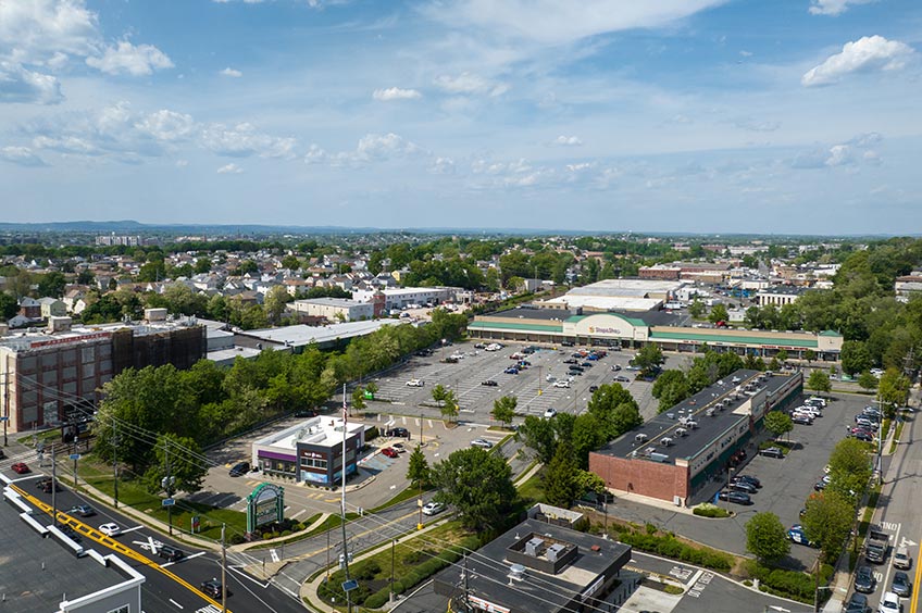 Overhead shot of Carlstadt Commons shopping center and its adjacent parking lot, captured from a high vantage point.