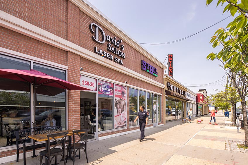 Sidewalk and shop storefront at Cross Bay Commons shopping center.