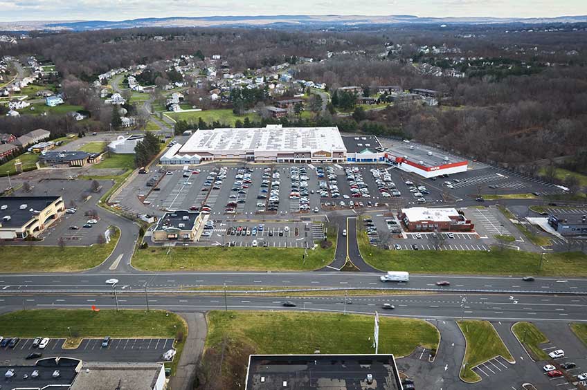 Aerial view of Newington Commons shopping center and its adjacent parking lot, captured from a high vantage point.