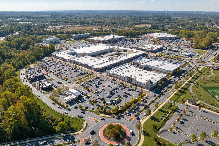 Aerial shot of Woodmore Towne Centre shopping center and its adjacent parking lot, captured from a high vantage point.