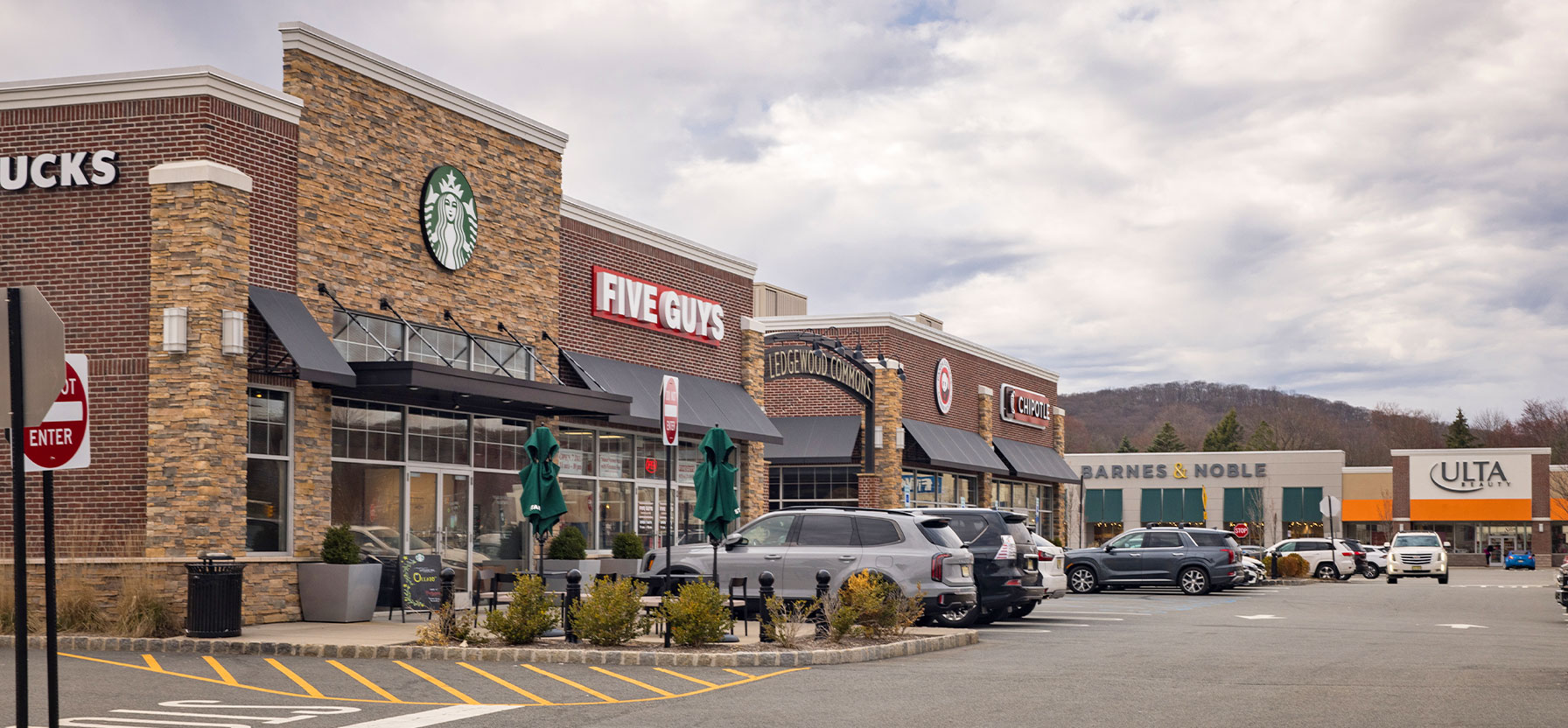 Image of Ledgewood Commons shopping center with various shops and parking spaces.