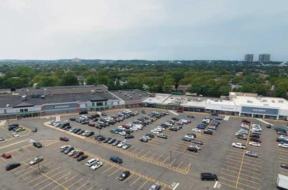 Aerial view of New Hyde Park shopping center and its adjacent parking lot, captured from a high vantage point.