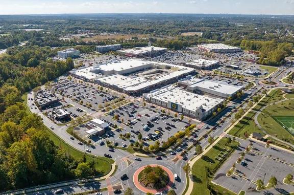 Aerial shot of Woodmore Towne Centre shopping center and its adjacent parking lot, captured from a high vantage point.